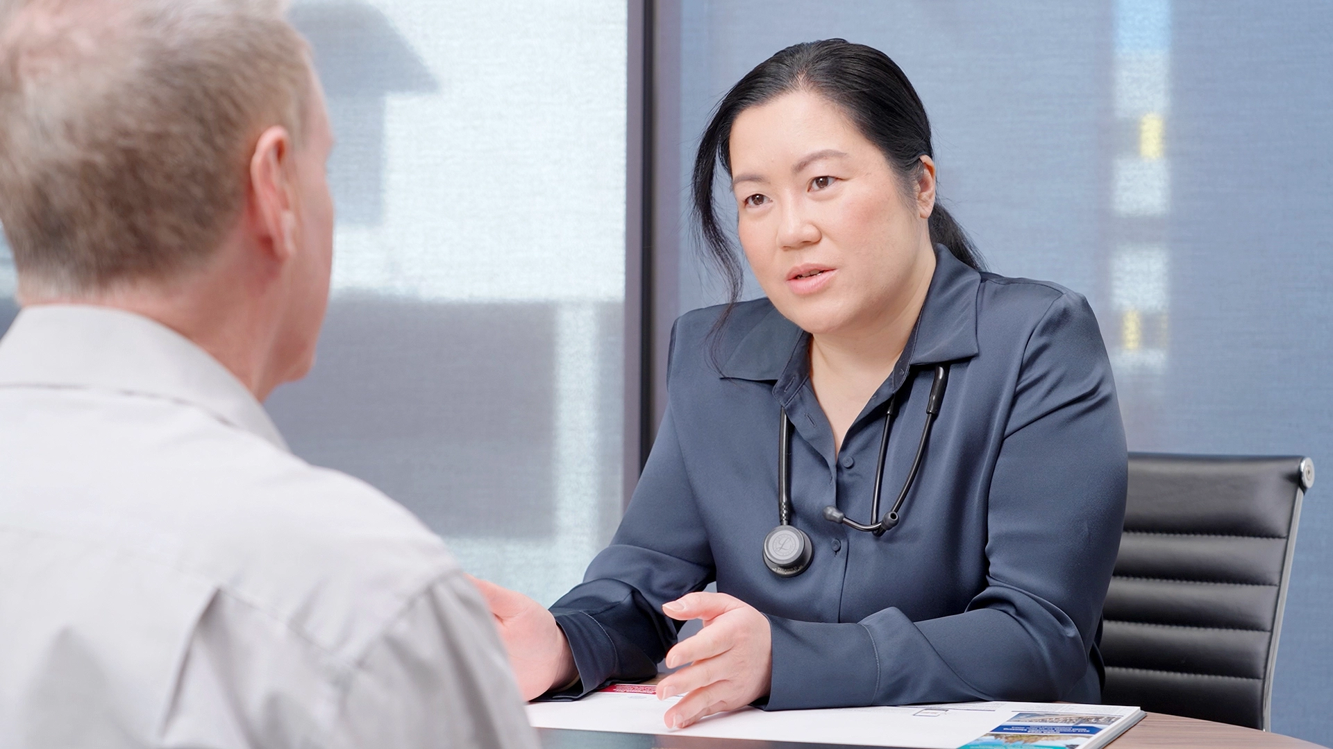Doctor talking with a patient across a desk on a Princeton Health video shoot by Ivory Media